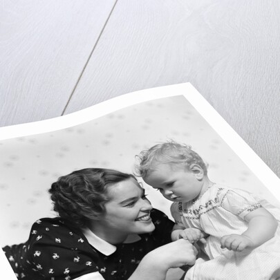 Woman mother smiling sitting playing with baby daughter by Anonymous