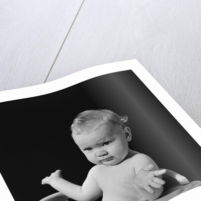 Baby in high chair making shrugging gesture by Anonymous