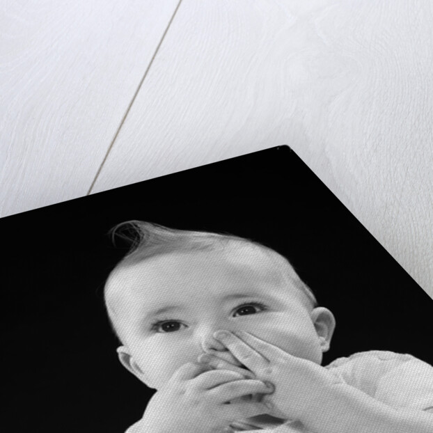 Portrait of baby covering mouth with hands fingers by Anonymous