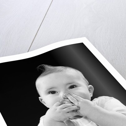 Portrait of baby covering mouth with hands fingers by Anonymous