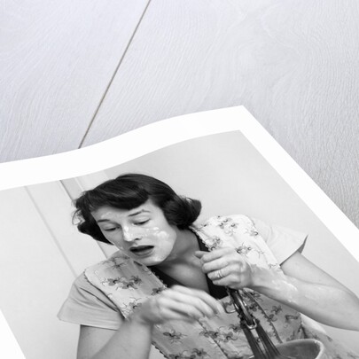 Woman face covered flour mixing ingredients reading brides cook book by Anonymous