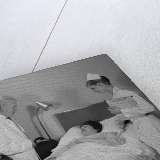 Doctor nurse husband talking with female patient in hospital bed by Anonymous