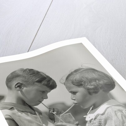 Children boy girl sharing drinking glass using straws by Anonymous