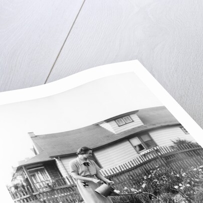 Woman watering garden with water can by Anonymous