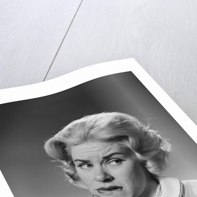 Blonde woman fist to chin worried serious facial expression by Anonymous