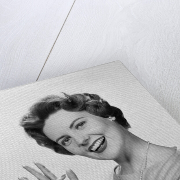 Smiling woman counting on fingers wearing pearls by Anonymous