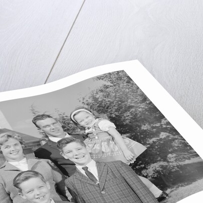 Family portrait father mother two sons and daughter in front of suburban house by Anonymous
