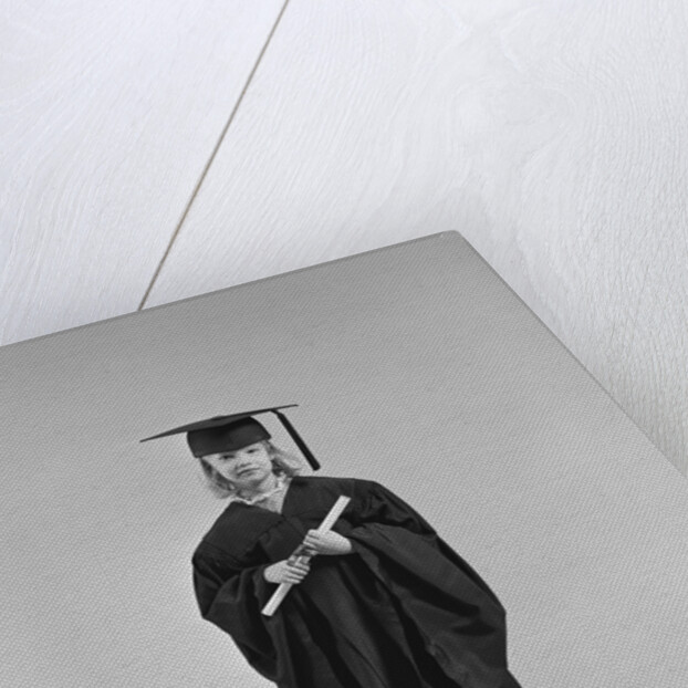 Girl wearing graduation cap gown holding diploma by Anonymous