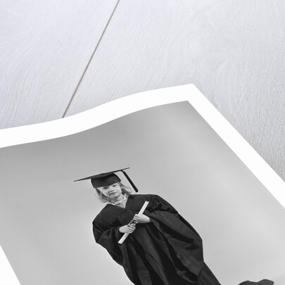 Girl wearing graduation cap gown holding diploma by Anonymous