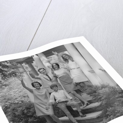 Family group of people standing on steps of house waving by Anonymous