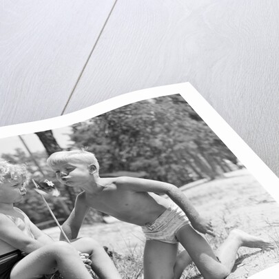 Blonde boy girl wearing bathing suits blowing on a pinwheel toy summer by Anonymous