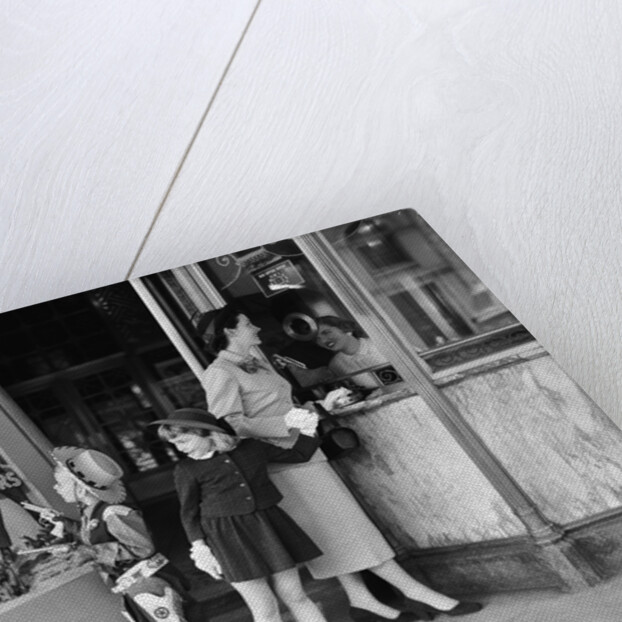 Mother and 2 children buying tickets to movie matinee boy wearing cowboy costume by Anonymous