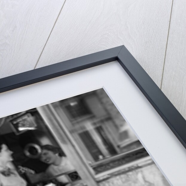 Mother and 2 children buying tickets to movie matinee boy wearing cowboy costume by Anonymous