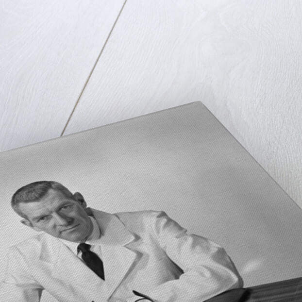 Portrait male doctor sitting at desk serious expression by Anonymous