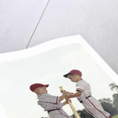 Two boys holding baseball bat little league uniforms by Anonymous