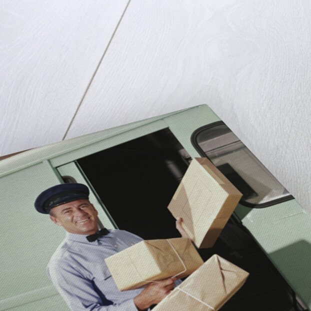 Delivery truck driver holding packages by Anonymous