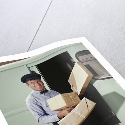 Delivery truck driver holding packages by Anonymous