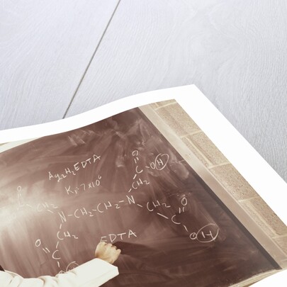 Science professor writing a formula for chelating agent on chalkboard by Anonymous