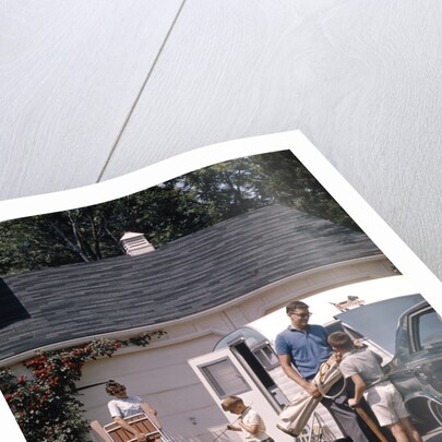 Family father mother 3 sons loading car and trailer for camping vacation by Anonymous