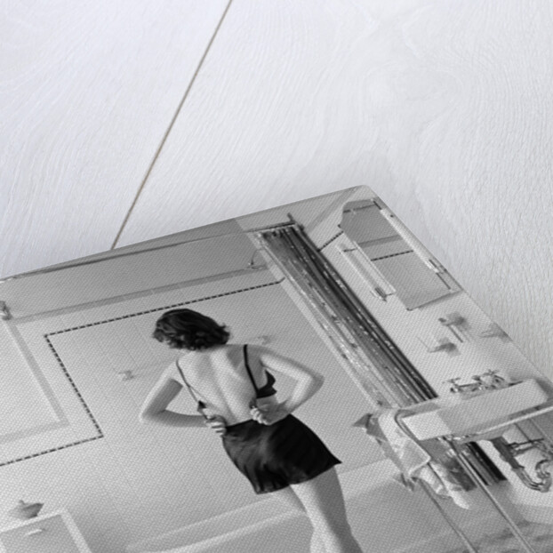 Back view of woman in bathroom fastening black bra by Anonymous