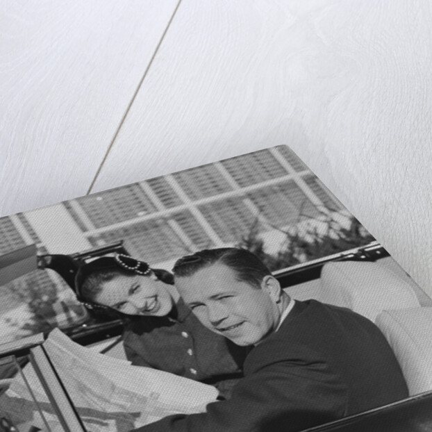 Husband wife man woman in automobile reading map by Anonymous