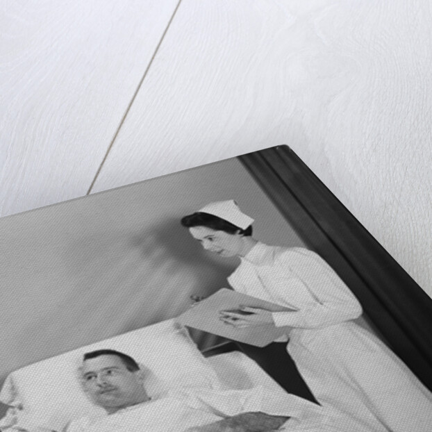 Man doctor woman nurse talking with male patient lying in hospital bed by Anonymous