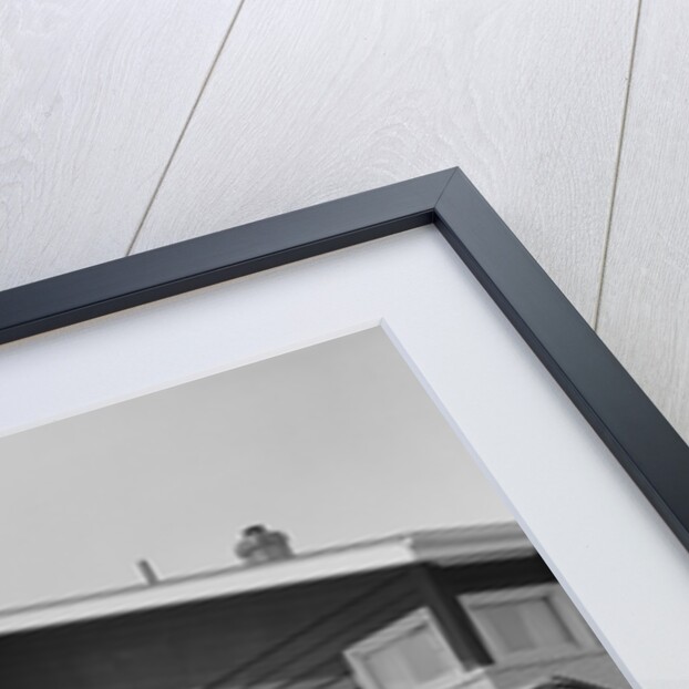 Couple man woman packing luggage into car trunk by suburban house by Anonymous