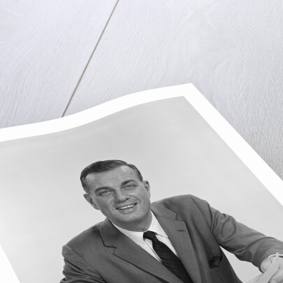 Smiling happy businessman pen in hand signing papers at desk by Anonymous