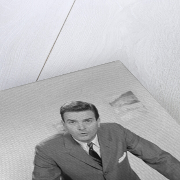 Businessman leaning over desk serious expression looking forward by Anonymous