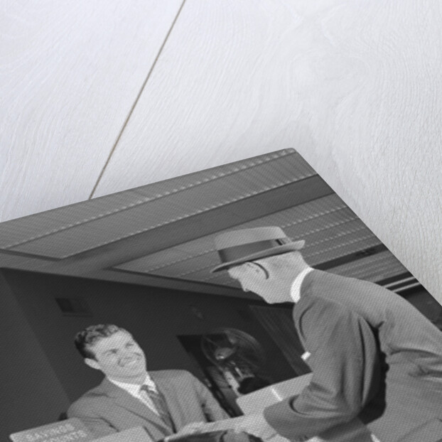 Businessman making a deposit into savings account with bank teller by Anonymous