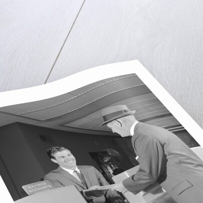 Businessman making a deposit into savings account with bank teller by Anonymous