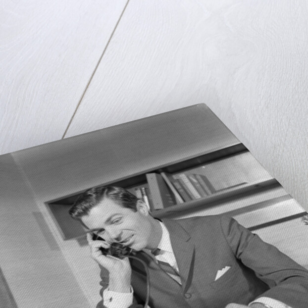 Businessman executive at desk talking on telephone by Anonymous