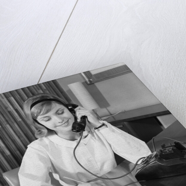 Secretary receptionist talking on telephone writing into desk calendar by Anonymous