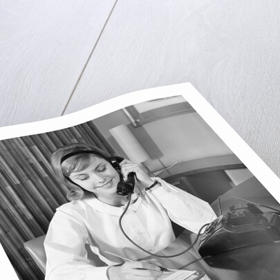 Secretary receptionist talking on telephone writing into desk calendar by Anonymous