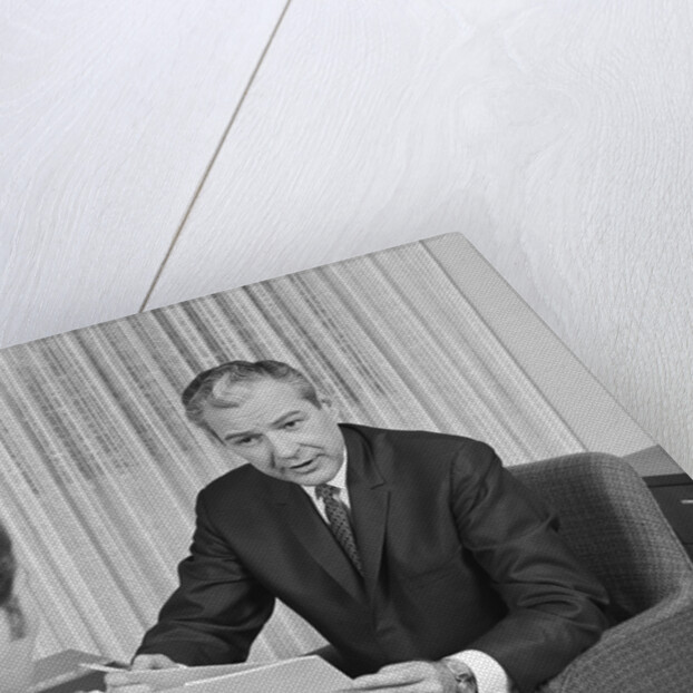 Man from behind meeting at desk of older businessman by Anonymous