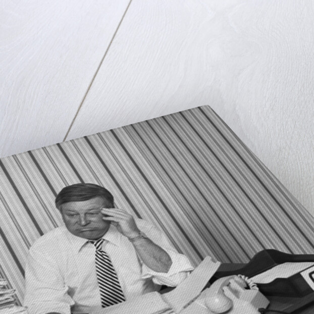 Concerned businessman staring large pile paperwork in in-box by Anonymous