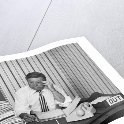 Concerned businessman staring large pile paperwork in in-box by Anonymous