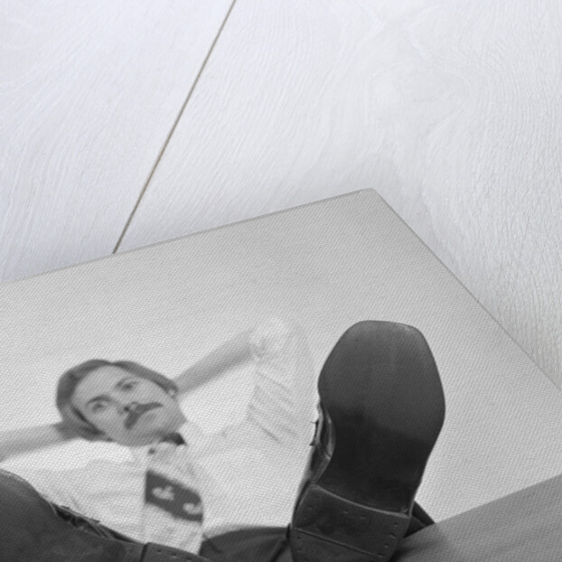 Businessman sitting feet up on desk by Anonymous