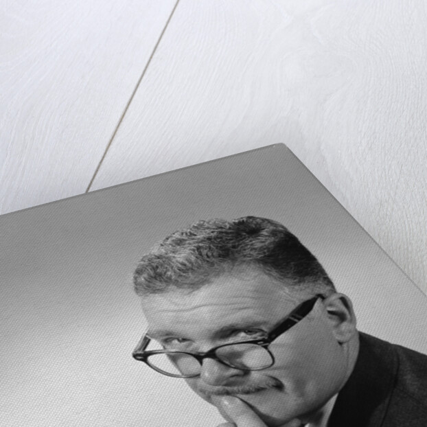 Middle aged man wearing eyeglasses low on nose quizzical facial expression by Anonymous