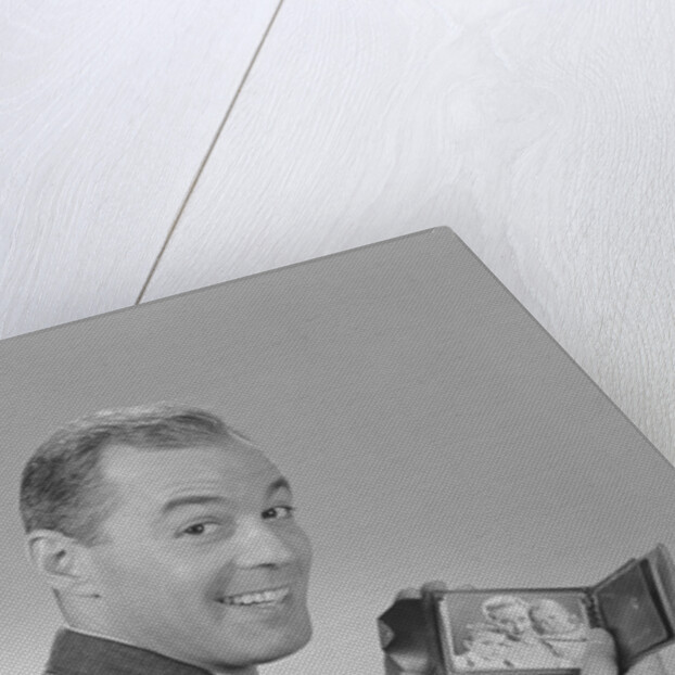 Man smiling holding wallet showing photo of family by Anonymous