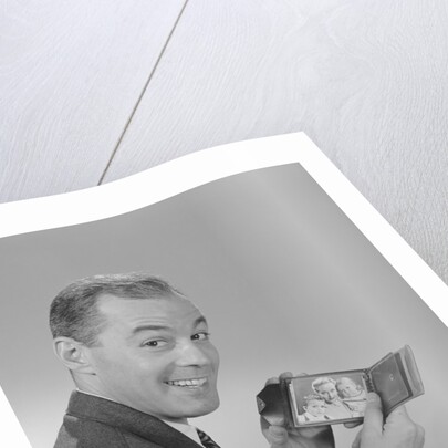 Man smiling holding wallet showing photo of family by Anonymous