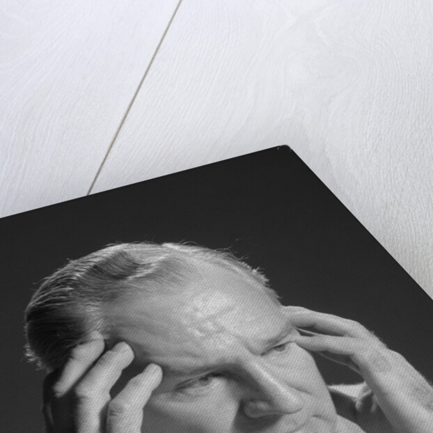 Older man with hands holding head temples by Anonymous
