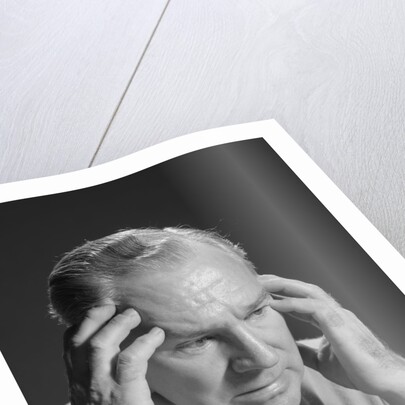 Older man with hands holding head temples by Anonymous