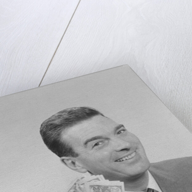 Smiling man holding a fistful of money fake bills by Anonymous