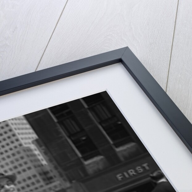 Businessman wearing suit hat carrying top coat standing on city street by Anonymous