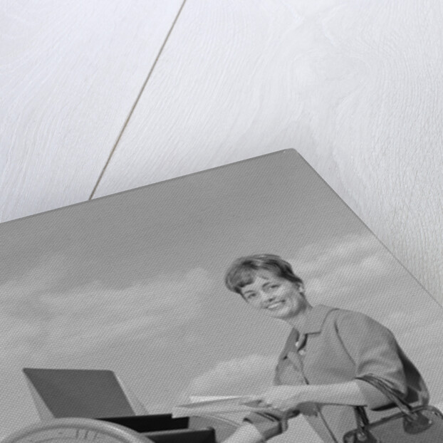 Smiling woman dropping letters in postal mail box by Anonymous