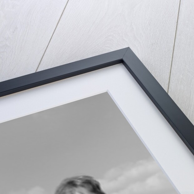 Smiling woman dropping letters in postal mail box by Anonymous