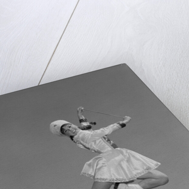 Woman majorette wearing band uniform holding baton jumping into the air by Anonymous