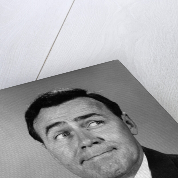 Businessman making funny face looking to the side by Anonymous