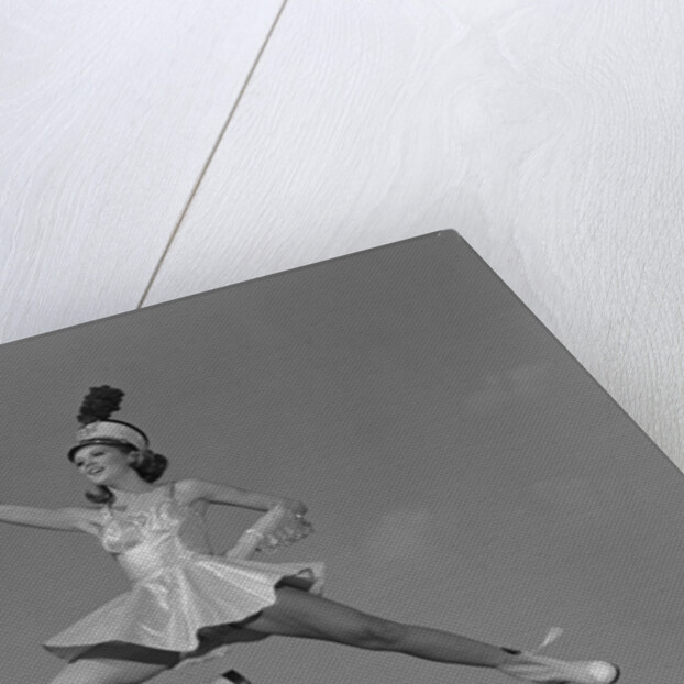 Woman majorette holding baton wearing short skirt uniform jumping into the air by Anonymous